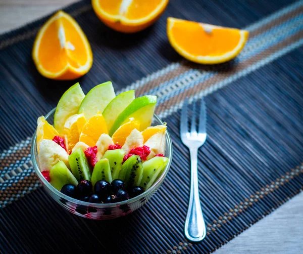 Salada Frutas Uma Placa Vidro Transparente Servida Tapete Bambu Escuro — Fotografia de Stock