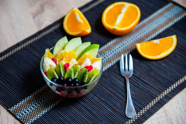 Obstsalat Einem Transparenten Glasteller Serviert Auf Einer Dunklen Bambusmatte Vor — Stockfoto