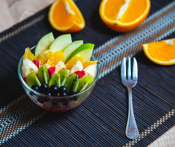 Salada Frutas Uma Placa Vidro Transparente Servida Tapete Bambu Escuro — Fotografia de Stock