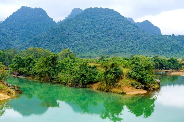 Une rivière avec de l'eau verte et des berges d'argile — Photo