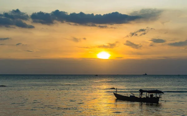 Silueta de barco de pesca en la playa en la puesta del sol de oro — Foto de Stock