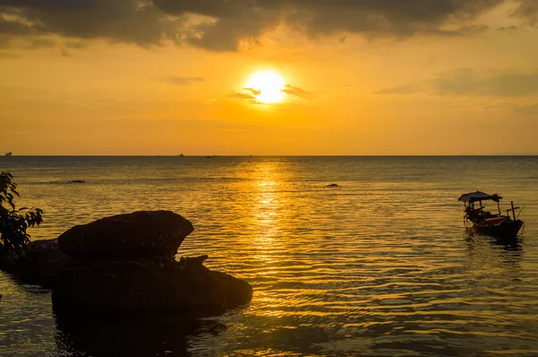 Silueta de barco de pesca en la playa en la puesta del sol de oro — Foto de Stock