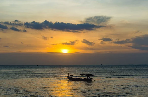 Silueta de barco de pesca en la playa en la puesta del sol de oro — Foto de Stock