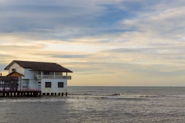 House Stilts üzerinde gündoğumu Denizi Tayland