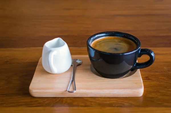 Sötét, fekete, kék kávé csésze kávé-americano, kanál és egy tej jug-állni egy — Stock Fotó