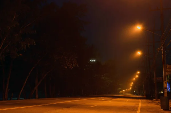 通りライトに照らされた霧に包まれた夜明け前に、の早朝の空の通り — ストック写真