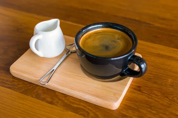 Sötét, fekete, kék kávé csésze kávé-americano, kanál és egy tej jug-állni egy — Stock Fotó
