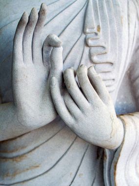 Buda'nın elleri ile beyaz bir heykelinin ayrıntı. Mudra parmaklarda