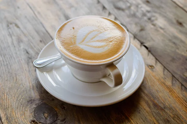 Cappuccino csésze a barna fa asztalon — Stock Fotó