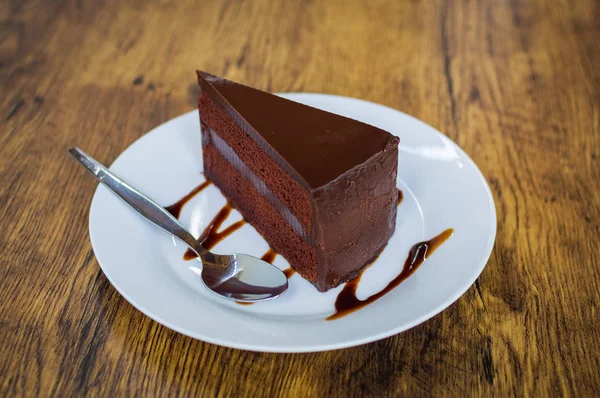 흰색 접시에 스푼으로 초콜릿 케이크의 조각 — 스톡 사진