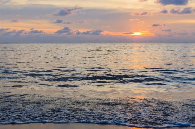 Deniz dalgaları üzerinde altın gün doğumu günbatımı