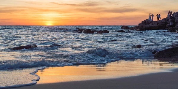 Gündoğumu veya günbatımı turuncu gökyüzü ile tropikal plaj deniz manzarası üzerinde