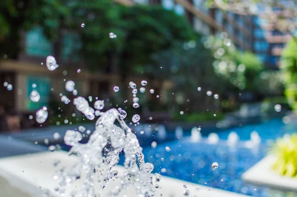 Congeler les éclaboussures de gouttelettes d'eau dans l'air près de la piscine — Photo