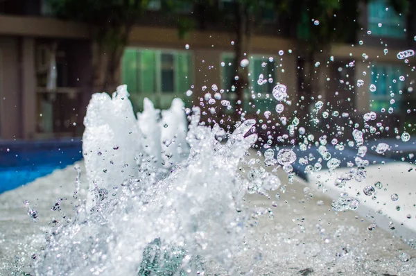 Congelare spruzzi d'acqua nell'aria vicino alla piscina — Foto Stock