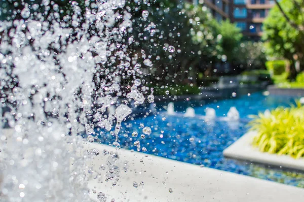 Congelare spruzzi d'acqua nell'aria vicino alla piscina — Foto Stock