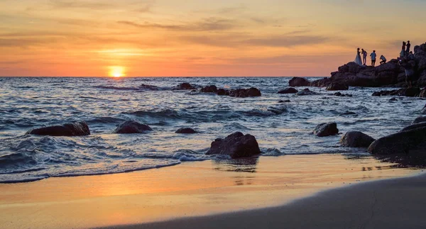 Gündoğumu veya günbatımı turuncu gökyüzü ile tropikal plaj deniz manzarası üzerinde