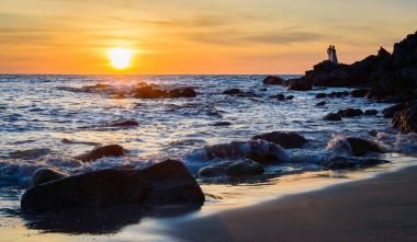 Gündoğumu veya günbatımı turuncu gökyüzü ile tropikal plaj deniz manzarası üzerinde