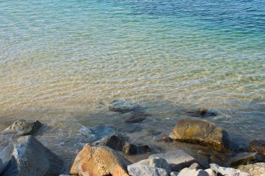 Güneşli bir günde bir taş Beach serinletici su bir dalga