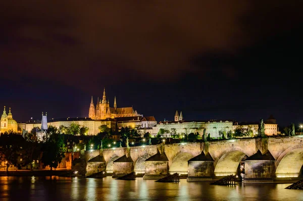 Brilhando Praga castelo e ponte Charles no início da noite, República Checa, Europa — Fotografia de Stock