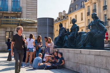 Genç insanlar kaldırımda museum yakınındaki statues yakınındaki bir Paris sokakta oturuyor. Fransa, Paris, 03 Ekim 2014.