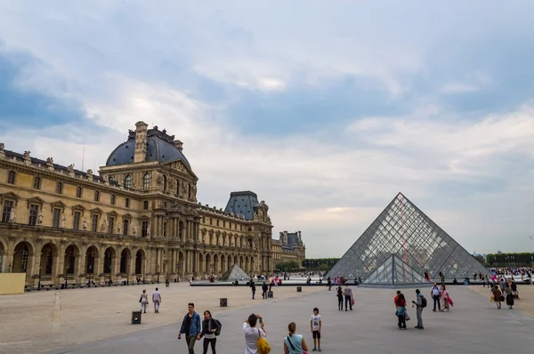 曇りの天気の中に人々 とルーブル美術館の正方形で表示します。フランス、2014 年 10 月 4 日. — ストック写真