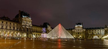 Işıklar şehri. Ünlü Louvre Müzesi ile piramit görünümünü akşam. Louvre Müzesi dünya çapında en büyük ve en çok ziyaret edilen müzelerinden biridir. Fransa, Paris, 6 Ekim 2014