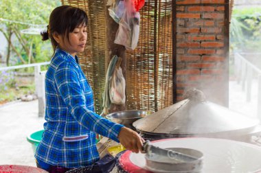 Uzun Tuyen, Binh Thuy, Can Tho, Vietnam, 30 Aralık 2016: bir pirinç keki Mekong Nehri Deltası'yapma belirsiz Vietnamlı bir kadın