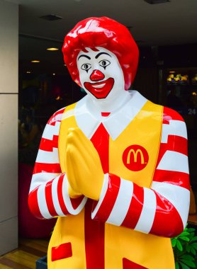 Thailand, Bangkok, March 02, 2013: Ronald McDonald Asian type of character near entryway to McDonalds restaurant in Bangkok, Thailand. Ronald McDonald is the main mascot of the McDonald's restaurants. clipart