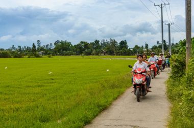 Co bölge, Thoi Lai kasaba, Can Tho, Vietnam, 21 Aralık 2106: motosiklet üzerinde yerel halk bir bulutlu gün boyunca pirinç paddies dar bir kırsal beton yol boyunca rides