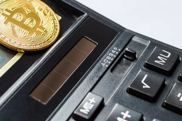 Goldene Bitcoin-Münze auf schwarzem Rechner aus nächster Nähe. — Stockbild Goldene Bitcoin-Münze auf Taschenrechner aus nächster Nähe — Stockfoto