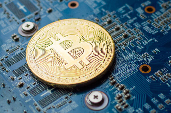 Золотой Bitcoin Cryptocurrency на компьютерной плате. Макро выстрел