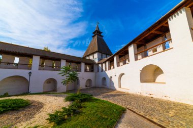 Avlunun beyaz taş duvarı, geniş kemerleri ve yol boyunca ahşap bir çatısı var. Bulutlu havalarda ve mavi bulutlarla kaplı. Tarihsel ve mimari kompleks Astrakhan Kremlin, Rusya