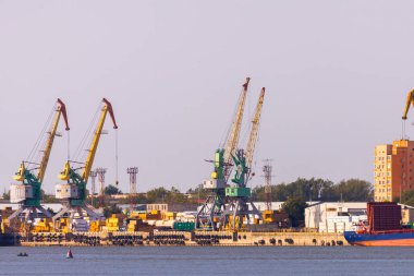 Şehir manzarasının arka planında iskele vinçleri olan sanayi manzarası