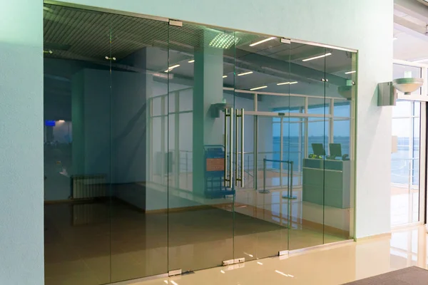 Empty room or shop behind glass window and doors in public place.