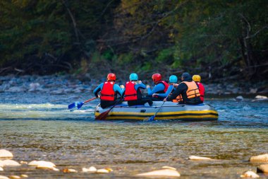 Bir grup genç dağ nehrinde rafting yapıyor..
