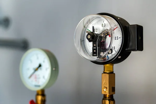 The equipment of the boiler-house, - valves, tubes, pressure gauges, thermometer. Close up of manometer, pipe, flow meter, water pumps and valves of heating system in a boiler room.