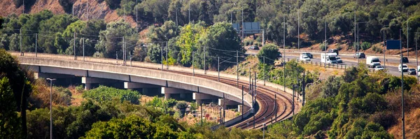 Кривая Железнодорожного Пути Параллельна Асфальтированной Дороге Проходящей Через Лес — стоковое фото