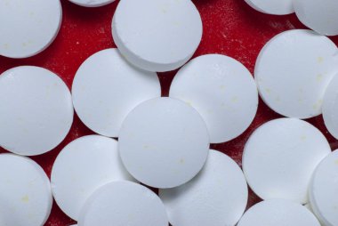 Kırmızı zemin üzerinde beyaz vitaminler yuvarlak