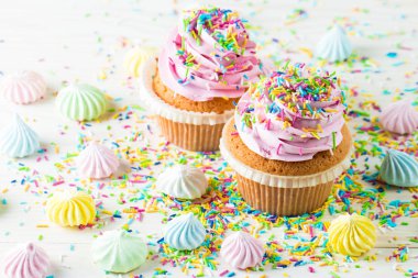 Vanilya, çilek, pembe ve beyaz krem, çikolata ve ahşap arka plan üzerinde ile cupcakes closeup. Seçici odak. Şekerli tatlı lezzetli yemekler kavramı muffin.