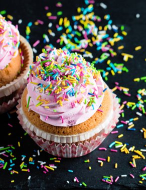 Vanilya, çilek, pembe ve beyaz krem, çikolata ve ahşap arka plan üzerinde ile cupcakes closeup. Seçici odak. Şekerli tatlı lezzetli yemekler kavramı muffin.