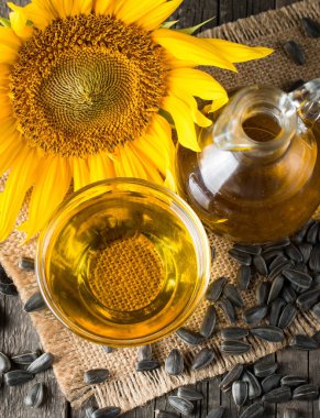 Ayçiçek yağı ve küçük torba geleneksel rustik ahşap arka plan ayçiçeği çekirdeği. Organik ve eko gıda kavramı. Sağlıklı gıda ve yağlar.