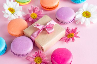 Pasta macarons, hediye kutusu, çay, kahve, cappuccino ve çiçek fotoğrafı. Tatlı romantik gıda acıbadem kurabiyesi kavramı. Sabah kahvaltı ve hediyeler.