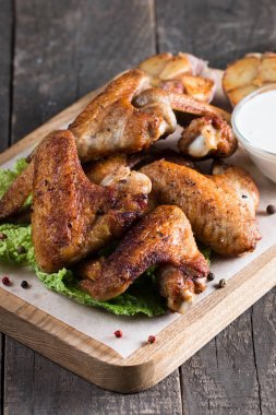 Yakın çekim fotoğraf Barbekü tavuk kanatlı patates ve bira. Barbekü soslar, ketçap, mayonez etli. Hızlı ve abur cubur kavramı. 