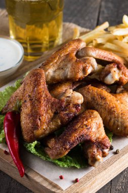 Yakın çekim fotoğraf Barbekü tavuk kanatlı patates ve bira. Barbekü soslar, ketçap, mayonez etli. Hızlı ve abur cubur kavramı. 