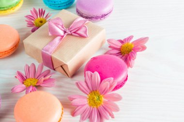 Pasta macarons, hediye kutusu, çay, kahve, cappuccino ve çiçek fotoğrafı. Tatlı romantik gıda acıbadem kurabiyesi kavramı. Sabah kahvaltı ve hediyeler.