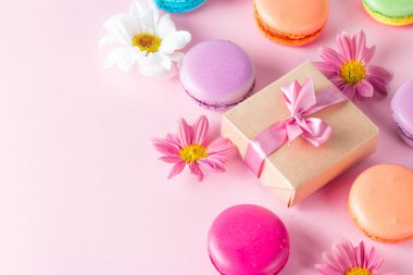 Pasta macarons, hediye kutusu, çay, kahve, cappuccino ve çiçek fotoğrafı. Tatlı romantik gıda acıbadem kurabiyesi kavramı. Sabah kahvaltı ve hediyeler.