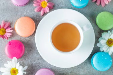 Pasta macarons, hediye kutusu, çay, kahve, cappuccino ve çiçek fotoğrafı. Tatlı romantik gıda acıbadem kurabiyesi kavramı. Sabah kahvaltı ve hediyeler.