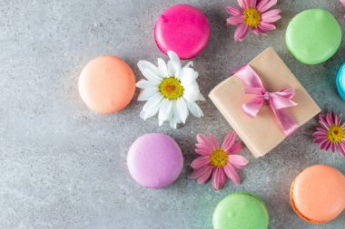 Pasta macarons, hediye kutusu, çay, kahve, cappuccino ve çiçek fotoğrafı. Tatlı romantik gıda acıbadem kurabiyesi kavramı. Sabah kahvaltı ve hediyeler.