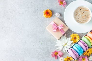 Pasta macarons, hediye kutusu, çay, kahve, cappuccino ve çiçek fotoğrafı. Tatlı romantik gıda acıbadem kurabiyesi kavramı. Sabah kahvaltı ve hediyeler.