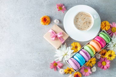 Pasta macarons, hediye kutusu, çay, kahve, cappuccino ve çiçek fotoğrafı. Tatlı romantik gıda acıbadem kurabiyesi kavramı. Sabah kahvaltı ve hediyeler.